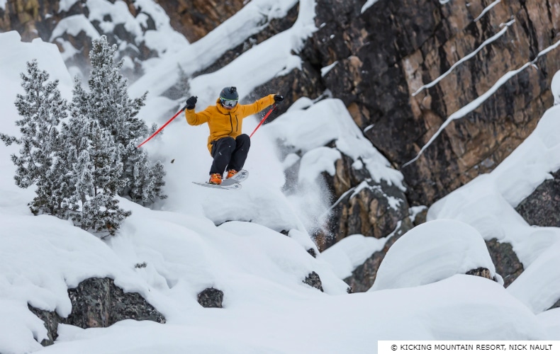 Skier in ornage jacket descends some extreme terrain at Kicking Horse Mountain Resort