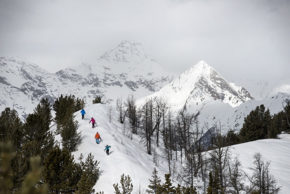 Skier clibing a peak to ski fresh powder snow