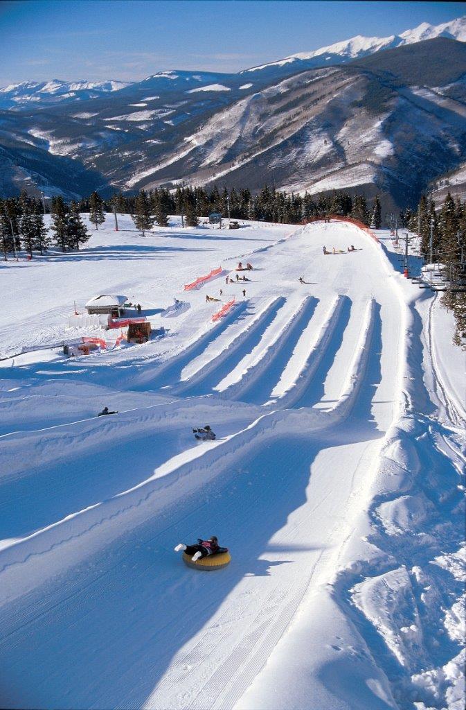 View from the top on a sunny day looking down 5 lanes of snow tubing fun